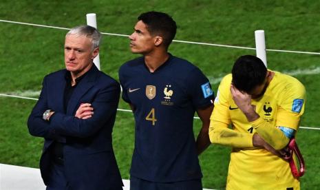 (Kiri-Kanan) Pelatih kepala Didier Deschamps dari Prancis, Raphael Varane, dan kiper Hugo Lloris bereaksi selama upacara penghargaan setelah Final Piala Dunia FIFA 2022 antara Argentina dan Prancis di stadion Lusail, Lusail, Qatar,   Ahad (18/12/2022).