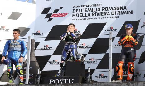  (Kiri) Pembalap Spanyol posisi kedua Joan Mir dari Team SUZUKI ECSTAR, pemenang Maverick Vinales dari Monster Energy Yamaha MotoGP, dan posisi ketiga Pol Espargaro dari Red Bull KTM Factory Racing merayakan di podium setelah balapan MotoGP di Emilia Romagna dan Riviera Di Rimini Motorcycling Grand Prix di depan posisi kedua Celestino Vietti dari SKY Racing Team VR46 (R) dan posisi ketiga Ogura Honda dari Team Asia (C) di Sirkuit Dunia Misano Marco Simoncelli, di Misano, Italia, 20 September 2020.