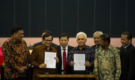 Koalisi Indonesia Hebat (KIH) dan Koalisi Merah Putih (KMP memperlihatkan naskah usai penandatanganan kesepakatan damai di Kompleks Parlemen, Senayan, Jakarta, Senin (17/11). 