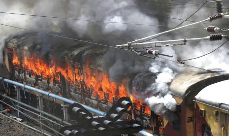 Kobaran api dari kereta api yang dibakar oleh pengunjuk rasa di stasiun kereta api Secundrabad di Hyderabad, India, Jumat, 17 Juni 2022. Ratusan pemuda yang marah melampiaskan kemarahan mereka dengan membakar gerbong kereta, merusak properti kereta api dan memblokir rel dan jalan raya dengan batu-batu besar sebagai serangan balasan berlanjut untuk hari kedua berturut-turut pada hari Jumat terhadap skema rekrutmen pemerintah jangka pendek yang baru untuk militer. Hampir 500 pengunjuk rasa jauh melebihi jumlah polisi saat mereka mengamuk selama lebih dari satu jam di stasiun kereta api Secundrabad di India selatan.