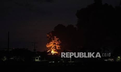 Kobaran api disertai kepulan asap hitam terlihat di Kilang Pertamina RU IV Cilacap, Jateng, Sabtu (12/6/2021). Pertamina telah menurunkan 50 tenaga pemadam untuk menangani kebakaran tersebut dengan menggunakan penyemprotan foam ke arah titik api, dan melokalisir titik api di sekitar tanki yang terbakar sejak Jumat (11/6/2021) malam. 