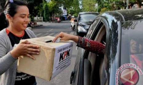 Koin Untuk KPK Seorang pengendara mobil memasukan uang ke dalam kotak sumbangan yang dibawa aktivis dari Komite Penyelidikan Pemberantasan Korupsi, Kolusi, dan Nepotisme (KP2KKN), saat berlangsung penggalangan dana 