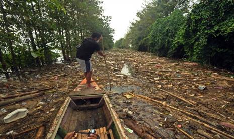 Koko (38) salah seorang warga Desa Bejalen, Kecmatan Ambarawa, Kabupaten Semarang, Jawa Tengah berupaya menyingkirkan sampah yang menutup permukaan kanal sungai Panjang, agar sampannya mampu melintas untuk mengakses ke tengah Danau Rawapening, Sabtu (10/4). Muara sungai tersebut tertutup sampah sepanjang 1 kilometer hingga mengganggu aktivitas nelayan desa setempat.