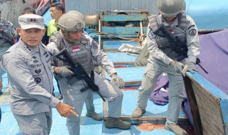 Komandan KN Pulau Marore-322 Bakamla RI Letkol Bakamla Yuli Eko Prihartanto (kiri) memperlihatkan palka tempat penyimpanan ikan dari kapal ikan asing berbendera Vietnam yang ditangkap di perbatasan.