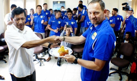 Komisaris PT. PBB Kuswara S Taryono (kiri) memberikan tumpeng kepada pelatih Persib Bandung Dejan Antonic pada perayaan HUT ke-83 Persib Bandung, di Bandung, Jawa Barat, Senin (14/3). 