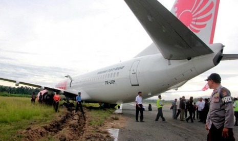   Komisi Nasional Keselamatan Transportasi (KNKT) memeriksa kondisi pesawat Lion Air di bandara Djalaludin, Gorontalo, Rabu (7/8).   (Antara/Adiwinata Solihin)