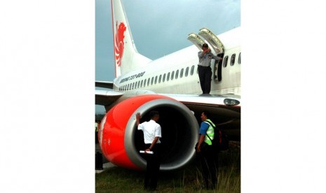   Komisi Nasional Keselamatan Transportasi (KNKT) memeriksa kondisi pesawat Lion Air di bandara Djalaludin, Gorontalo, Rabu (7/8).   (Antara/Adiwinata Solihin)