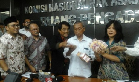 Komisioner Komisi Nasional HAM, Siane Indriyani menunjukan uang diberikan Densus 88 untuk keluarga Siyono saat rilis hasil autopsi kematian Siyono di Komnas HAM