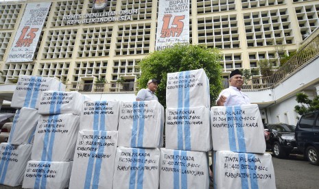 Komisioner KPU Arief Budiman (kanan) bersama Kasubag Logistik KPUD Papua Abdul Aziz Noch (kiri) memeriksa paket logistik tinta Pilkada yang akan dikirim ke Papua, Jakarta, Jumat (13/1).