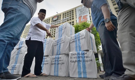 Komisioner KPU Arief Budiman (kiri) memeriksa paket logistik tinta Pilkada yang akan dikirim ke Papua, Jakarta, Jumat (13/1).