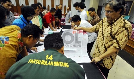 Komisioner KPU Hadar Gumay (kanan) merapihkan surat suara saat rapat koordinasi dengan perwakilan partai politik di kantor Komisi Pemilihan Umum (KPU), Jakarta, Senin (23/12). (Republika/Tahta Aidilla)