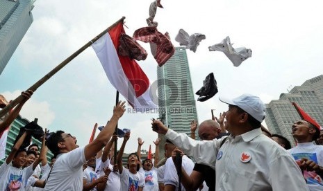  Komunike Bersama Anak Menteng Bersatu melempar atribut capres-cawapres saat melakukan aksi damai di Bundaran HI, Jakarta, Senin (21/7).  (Republika/ Tahta Aidilla)