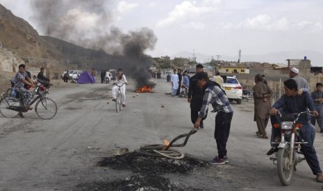 Komunitas Hazara membakar ban untuk memblokir jalan utama dalam protes mengecam bom bunuh diri di pasar di Quetta, Pakistan, Sabtu (13/4).