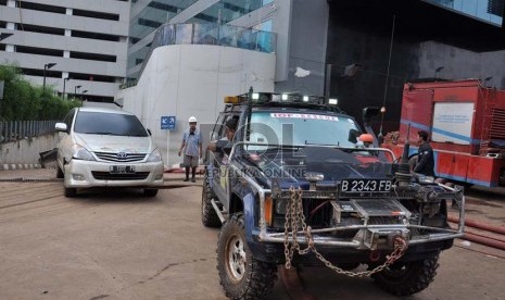   Komunitas Indonesian Off-Road Federation (IOF) turut membantu mengevakuasi sejumlah kendaraan yang terendam banjir di ruang parkir basement Plaza UOB,Jakarta Pusat,Senin (21/1). (Republika/Rakhmawaty La'lang)