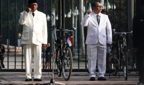 Komunitas sepeda dengan memakai kostum Soekarno dan Bung Hatta mengikuti upacara bendera di kawasan Senayan, Ahad (17/8). 