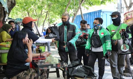 Komunitas Warteg (Kowarteg) Indonesia di Jawa Timur lakukan gerakan berbagi ceria dengan memberikan sarung tangan dan operasi makan gratis kepada puluhan ojol yang mangkal di Stasiun Pasar Turi, Kota Surabaya, Jawa Timur. 