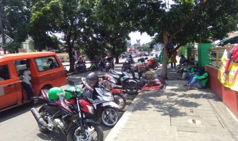 Kondisi bahu jalan di depan Mall Tamini Square, Jakarta Timur terlihat seperti parkir liar. Hal ini disebabkan oleh banyaknya kendaraan bermotor yang parkir di bahu jalan tersebut.  Kebanyakan dari mereka yang memarkir di bahu jalan ini adalah para pengemudi ojek online. 