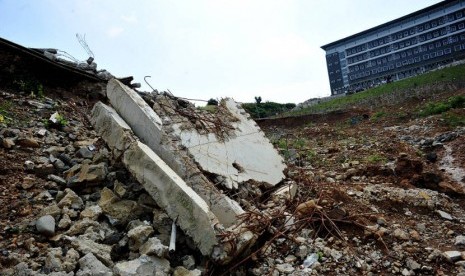  Kondisi bangunan gardu istrik yang tinggal puing dengan latar belakang wisma atlet putra di Bukit Hambalang, Bogor, Jawa Barat, Rabu (30/5). (Edwin Dwi Putranto/Republika)