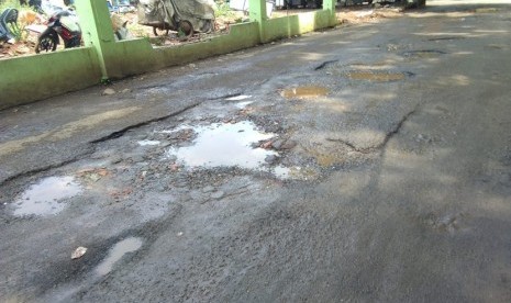 Kondisi jalan di pintu masuk Gelanggang Olahraga (GOR) Bekasi, Kota Bekasi rusak parah.