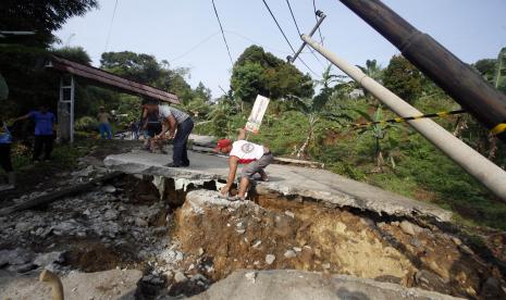 Kondisi jalan yang rusak akibat pergerakan tanah di Bojong Koneng, Babakan Madang, Kabupaten Bogor, Jawa Barat. Rumah terdampak pergeseran tanah di Kampung Curug Bogor telah dibangun dan diperbaiki.