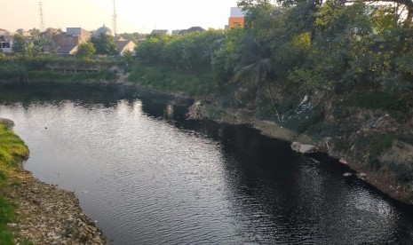 Kondisi Kali Bekasi yang tercemar dengan airnya yang tampak berwarna hitam di Jembatan Cipendawa, Rawalumbu, Kota Bekasi, Jumat (26/7). 