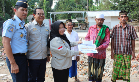 Konsul Imigrasi KJRI Johor Bahru I Gusti M Ibrahim (kiri) menyerahkan bantuan pembangunan Mushala Ar Rahmah yang rusak akibat gempa di Dusun Montong Dao, Desa Teratak, Kecamatan Batukliang Utara, Lombok Tengah, Rabu (10/10) kemarin.  