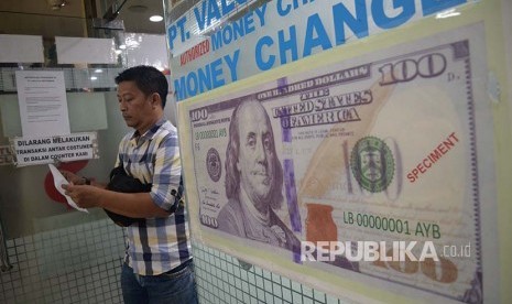 Konsumen menukarkan mata uang asing di jasa penukaran uang asing Valuta Artha Mas ITC Kuningan, Jakarta,Kamis (26/4). Nilai tukar rupiah rebound pada perdagangan Kamis (26/4), Rupiah di tutup menguat 0,22% ke posisi Rp 13.891 per dolar AS, setelah dibuka di level Rp 13.919 per dolar AS.