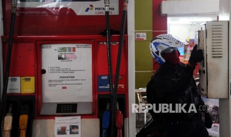 Konsumen sedang mengambil struk pembelian bensin.