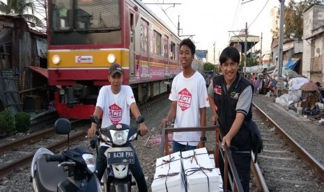 Koordinator relawan Masyarakat Relawan Indonesia (MRI) Jakpus M Syahri alias Mas Coy bersama relawan ACT membagikan menu buka puasa di kawasan Petamburan, Tanah Abang, Jakarta Pusat