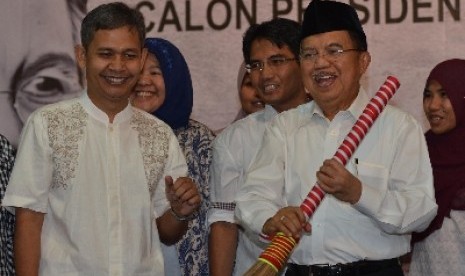 Koordinator Relawan Matahari Indonesia (RMI) Muhammad Izzul Muslimin menyerahkan sapu secara simbolis kepada Calon wakil Presiden Jusuf Kalla sebagai simbol untuk membersihkan Indonesia dari Korupsi saat menghadiri deklarasi Relawan Matahari Indonesia (RMI