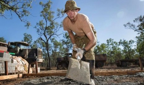 Kopral Jason Neumann sedang membuat lantai semen sebagai bagian dari Army Aboriginal Community Assistance Program (AACAP) di Queensland utara. 