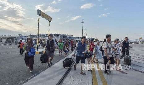 Korban gempa selamat berjalan di Bandara Mutiara Sis Aljufri untuk dievakuasi di Palu, Sulawesi Tengah, Sabtu (29/9).