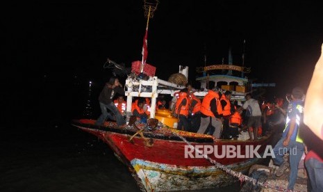 Korban KM Santika Nusantara yang terbakar turun dari perahu nelayan yang membawanya di Pelabuhan Kalianget, Sumenep, Jawa Timur. Jumat (23/8/2019). Sedikitnya 80 korban dievakuasi ke Kabupaten Sumenep dan sebagian ke Surabaya. 