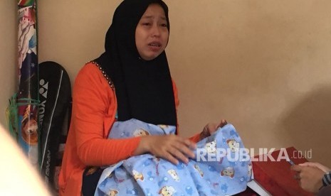 Korban penculikan bayi, ibu bernama Marlina (33) menggenggam bedong biru motif sama saat bayinya hilang.