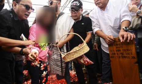 Korban selamat dalam kasus pembunuhan Pulomas Zanette Kalila (kedua kiri) menabur bunga di pusara makam kakaknya Dianita Gemma Dzalfayla yang menjadi korban tewas dalam kasus itu di TPU Tanah Kusir, Jakarta, Rabu (28/12). 