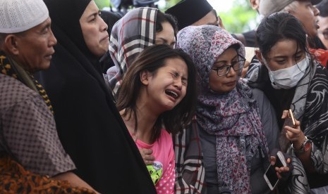 Korban selamat dalam kasus pembunuhan Pulomas Zanette Kalila (tengah) bersama Ibunya Rosi Herawati (kedua kiri) menghadiri pemakaman keluarga mereka yang tewas dalam kasus itu di TPU Tanah Kusir, Jakarta, Rabu (28/12). 