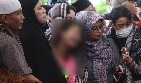   Korban selamat dalam kasus pembunuhan Pulomas Zanette Kalila (tengah) bersama Ibunya Almyanda Safira (kedua kiri) menghadiri pemakaman keluarga mereka yang tewas dalam kasus itu di TPU Tanah Kusir, Jakarta, Rabu (28/12). 