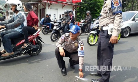 Korlantas Polri bersama dengan Road Accident Rescue Traffic Accident Analysis (RAR TAA) melakukan olah TKP di Jalan Raya Puncak, Turunan Selarong, Cipayung, Megamendung, Kabupaten Bogor, Ahad (23/4). 