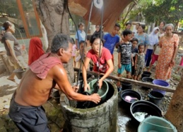 KRISIS AIR BERSIH. Warga menimba sumur tanah untuk mengatasi krisis air bersih Warga mengisi air ke dalam ember saat antre air bersih karena aliran pipa air terganggu, di Kampung Kayu Tinggi, Bulak Indah, Cakung, Jakarta Timur, Jumat (7/5).