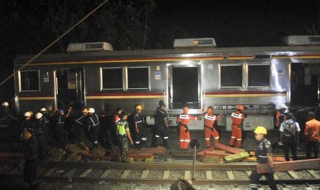 KRL Anjlok. Sejumlah petugas PT KAI melakukan evakuasi pengangkatan badan gerbong KRL Commuter Line 1722 yang anjlok di pintu perlintasan Kebon Pedes, Tanah Sareal, Kota Bogor, Jawa Barat, Ahad (10/3) malam.