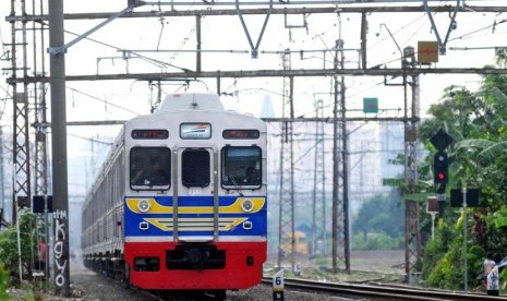  KRL Commuter Line melintas di kawasan Bukit Duri, Jakarta, Selasa (17/6). 