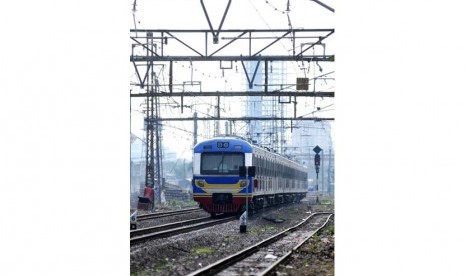 KRL Commuter Line melintas di kawasan Bukit Duri, Jakarta, Selasa (17/6).