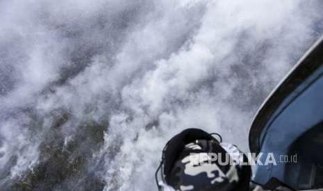 Kru helikopter MI-18Mtv-1 milik Badan Nasional Penanggulangan Bencana (BNPB) mengamati kepulan Asap yang membubung tinggi dari lahan yang terbakar di Pulu Beruang, Tulung Selapan, Ogan Komering Ilir (OKI), Sumatera Selatan, Kamis (13/9). BPBD Provinsi Sumatera Selatan masih berupaya melakukan pemadaman kebakaran yang terjadi sejak Rabu (12/9).