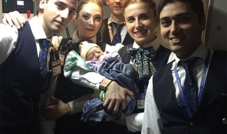 Kru pesawat Turkish Airlines memegang bayi Bennel yang lahir di dalam pesawat.