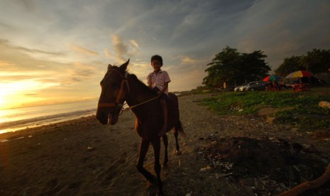 KUDA PANTAI PADANG. Anak-anak menunggangi seekor kuda yang disewakan di kawasan pantai Purus, Padang, Sumbar, Senin (29/4). 