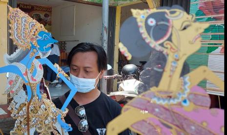 Kusbiantoro saat menunjukkan beberapa karakter Wayang Jatakamala, saat ditemui di Pasar UMKM Gua Kerep, Ambarawa, Kabupaten semarang, Jawa Tengah, Ahad (10/10). Ia merupakan satu dari beberapa gelintir seniman yang membuat karakter tokoh Wayang Jatakamala ini. (bowo pribadi)