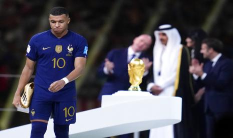  Kylian Mbappe dari Prancis berjalan dengan penghargaan Sepatu Emas sebagai pencetak gol terbanyak turnamen selama upacara penghargaan setelah Argentina mengalahkan Prancis dalam pertandingan sepak bola final Piala Dunia di Stadion Lusail di Lusail, Qatar,  Ahad (18/12/2022).