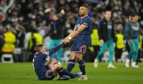 Kylian Mbappe dari PSG membantu rekan setimnya Marco Verratti bangkit setelah kalah di Liga Champions, babak 16 besar, pertandingan sepak bola leg kedua antara Real Madrid dan Paris Saint-Germain di stadion Santiago Bernabeu di Madrid, Spanyol, Rabu, 9 Maret 2022.