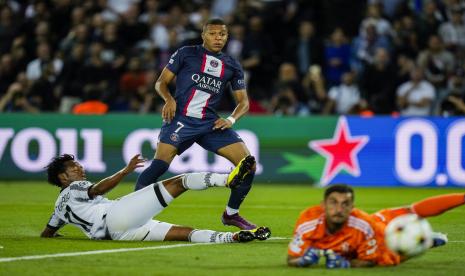  Kylian Mbappe dari PSG (tengah) menendang bola di dekat Juan Cuadrado dari Juventus, kiri, selama pertandingan sepak bola Liga Champions Grup H di Stadion Parc des Princes, di Paris, Rabu (7/9/2022) dini hari WIB.