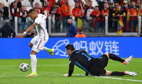 Kylian Mbappe (kiri) dari Prancis beraksi melawan kiper Belgia Thibaut Courtois selama pertandingan sepak bola semifinal UEFA Nations League antara Belgia dan Prancis di Turin, Italia, 7 Oktober 2021.